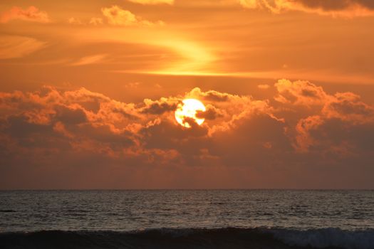 A beautiful sunset with vibrant colors over a calm ocean landscape, showcasing golden hour hues.