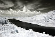 壮观的天空下，雪山与宁静的湖泊在令人惊叹的红外图像中展现