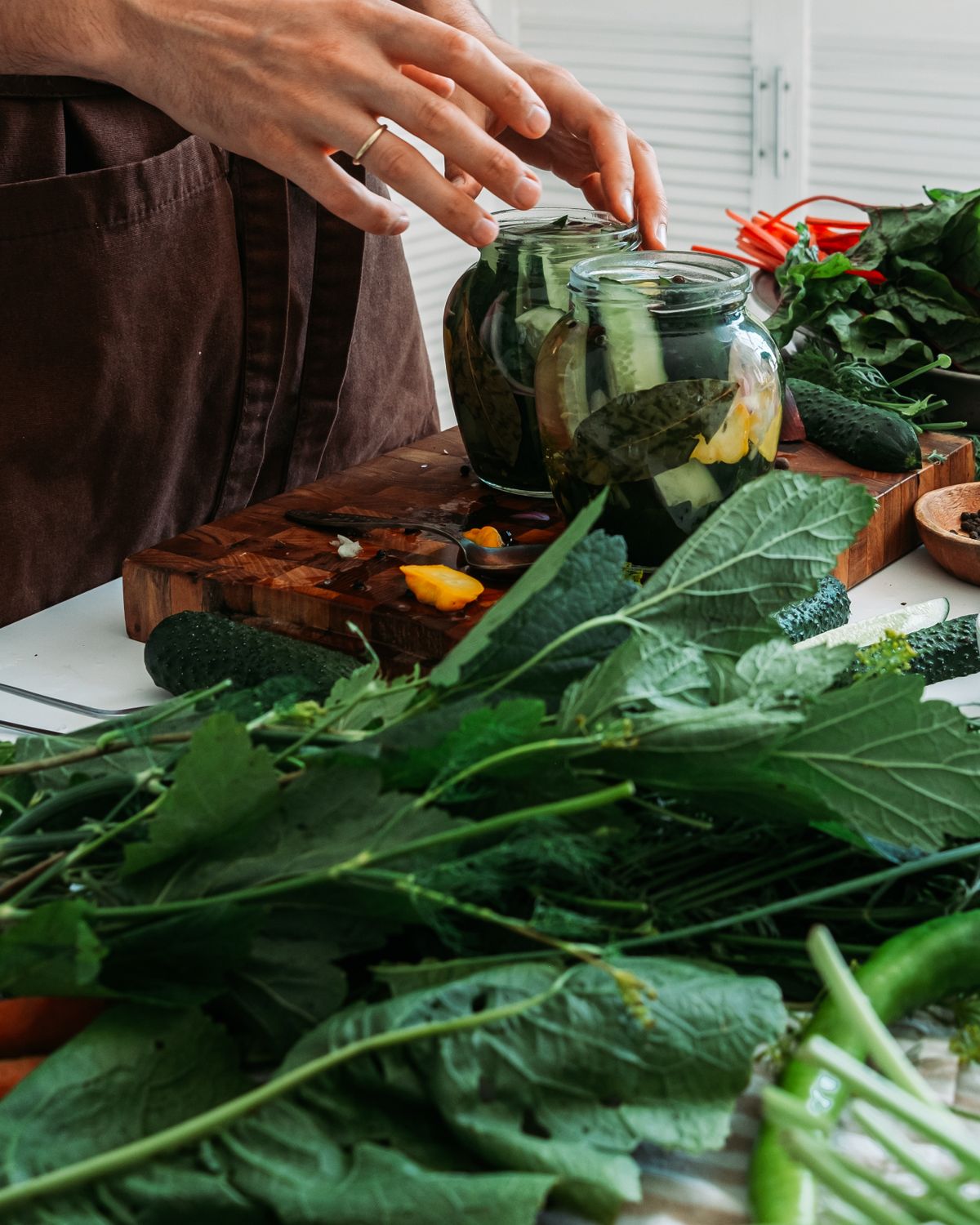 A hand holding a glass jar of assorted spices for spice storage ideas
