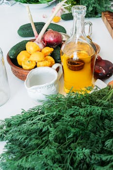 A vibrant display of fresh vegetables and herbs with olive oil on a table, perfect for culinary inspiration.