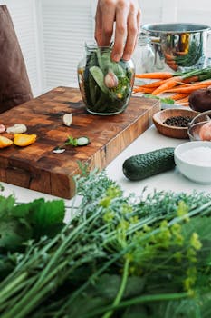 Fresh vegetables being prepared for pickling in a kitchen setting.
