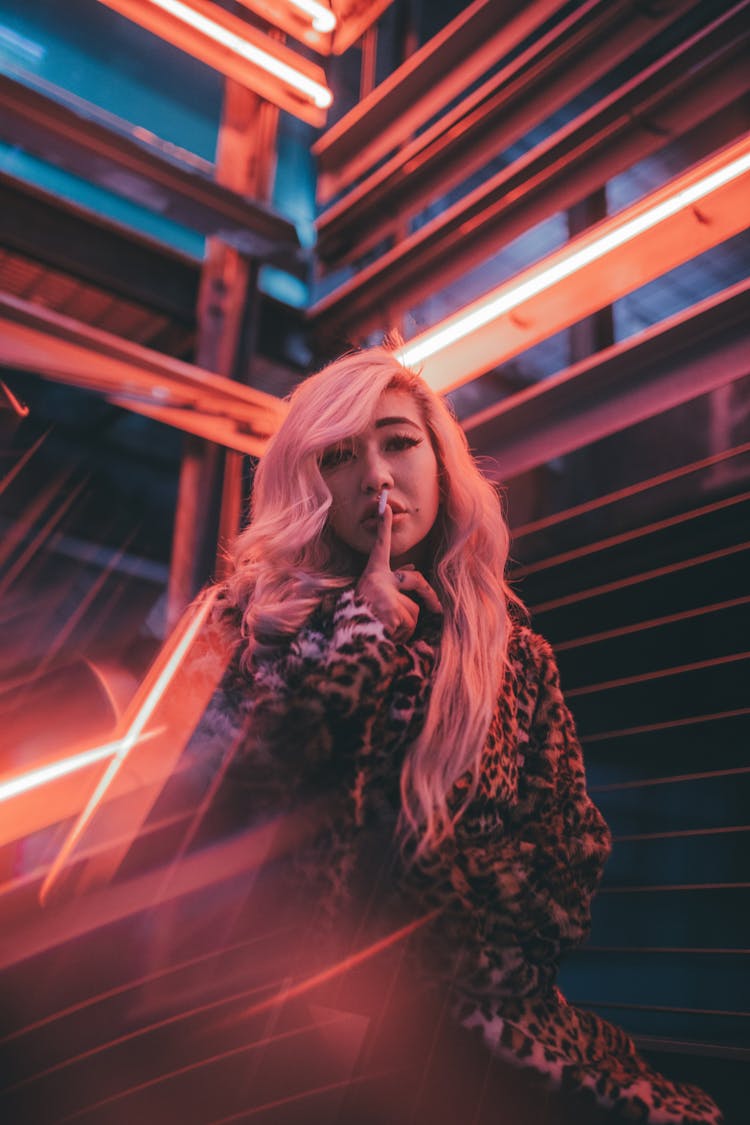 Blonde Woman In Tiger Print Dress Doing Hush Sign