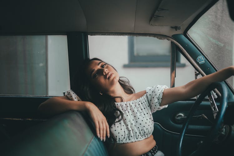 Woman In White And Black Polka Dot Crop Top Sitting On Driver Seat