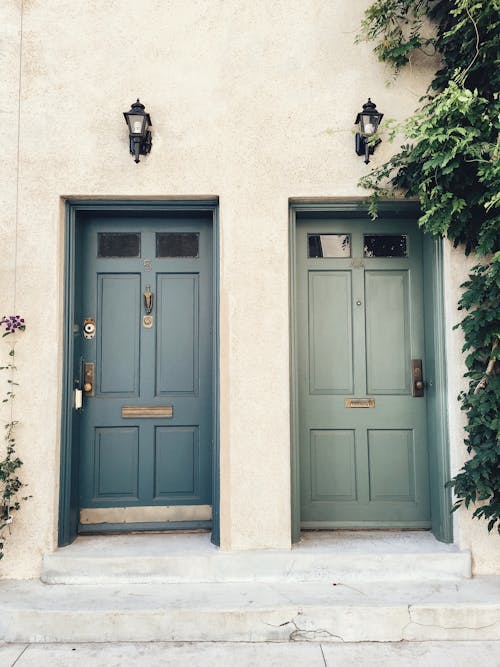 Two Adjacent Wooden Front Doors with Lampposts