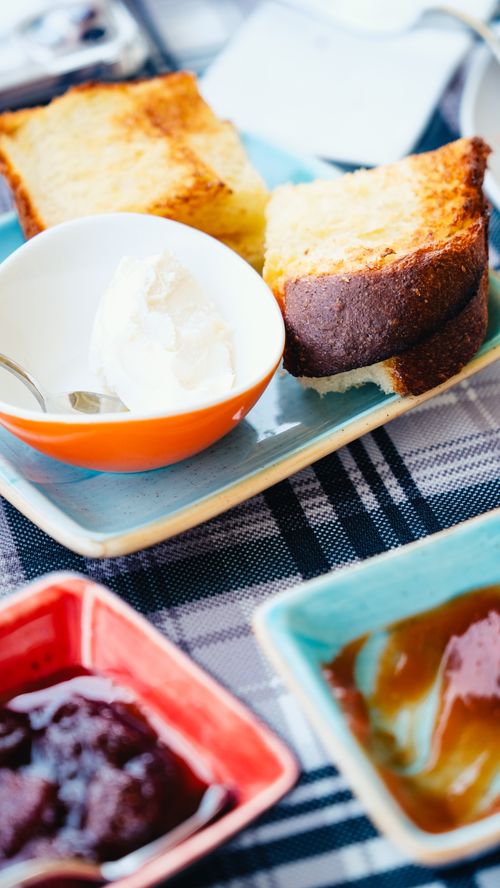 Free A delectable breakfast setup featuring toasted bread with creamy spread on a ceramic plate. Stock Photo