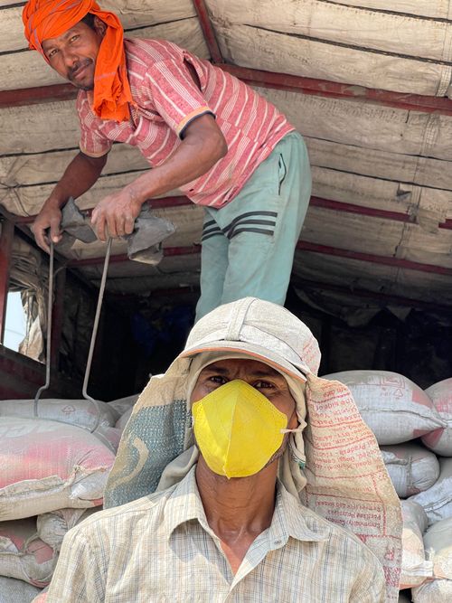 Free Two workers in Sahibzada Ajit Singh Nagar wearing protective gear and loading supplies. Stock Photo