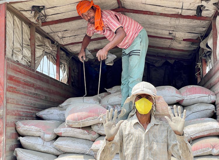 Men Unloading Bags From Truck