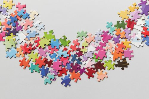 Free Vibrant jigsaw puzzle pieces scattered on a clean white background. Perfect for creativity concepts. Stock Photo