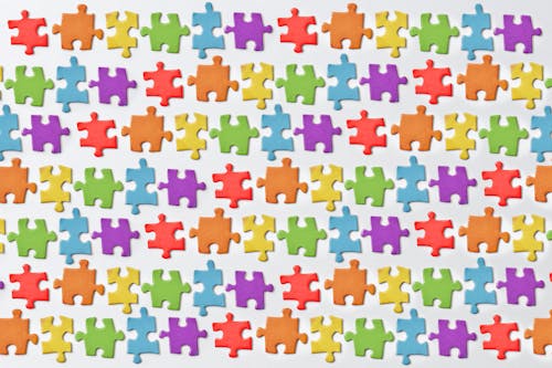 Close-Up Shot of Jigsaw Puzzles on a White Surface