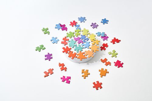 Free A vibrant collection of colorful puzzle pieces scattered on a clean, white background. Stock Photo