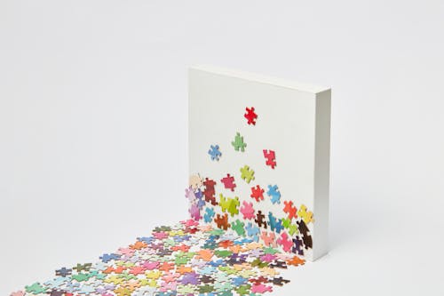 Studio Shot of Colorful Jigsaw Pieces and a Rectangular Block