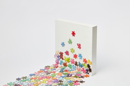 Free Colorful jigsaw puzzle pieces scattered on a white background creating a unique abstract visual. Stock Photo