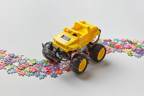 Studio Shot of a Toy Truck Riding Along a Road Made of Jigsaw Pieces