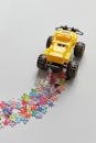 Yellow Toy Truck Running Over Puzzle Pieces
