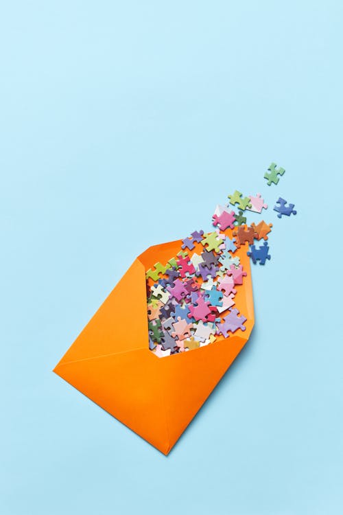 Free Orange Envelope With Colorful Puzzle Pieces Stock Photo