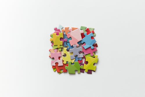 Free Green Blue and Yellow Puzzle Pieces on White Background Stock Photo