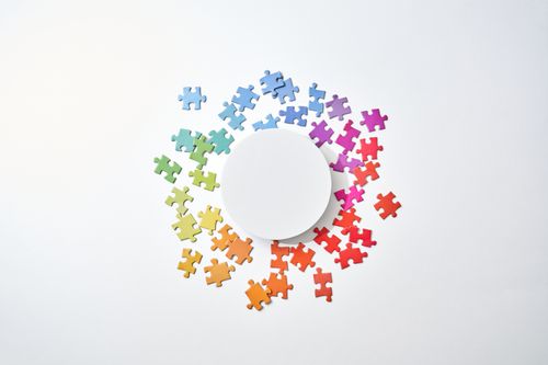 Free Circular arrangement of rainbow-colored puzzle pieces on a white backdrop, symbolizing diversity. Stock Photo