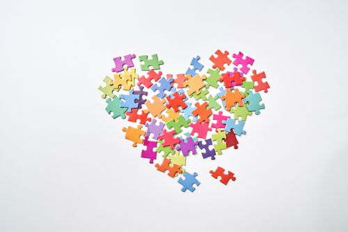 Free Vibrant jigsaw pieces arranged in a heart shape against a white backdrop. Stock Photo