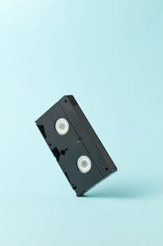 A classic VHS tape captured against a simple blue backdrop, evoking nostalgia.