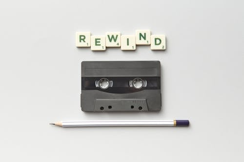 A Cassette, a Pen and the Word Rewind from Scrabble Letter Tiles 