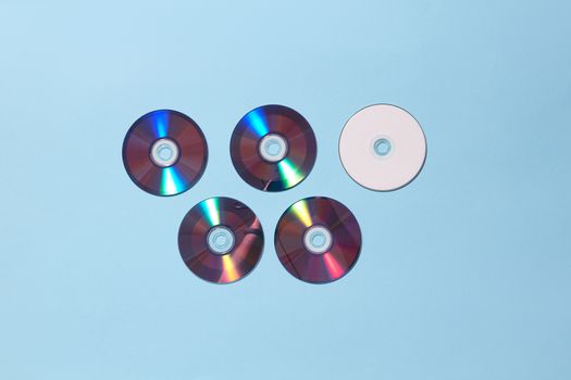 Five CDs arranged on a light blue background creating a modern and minimalist look.
