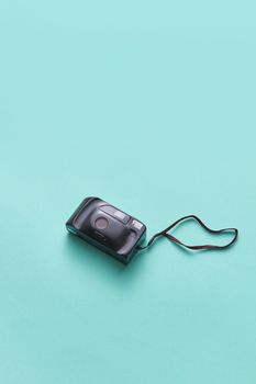 Top view of a classic vintage camera against a mint green backdrop. Ideal for photography themes.