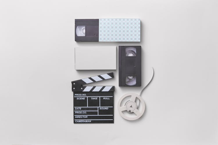 Old Cassettes And Clapperboard On White Surface