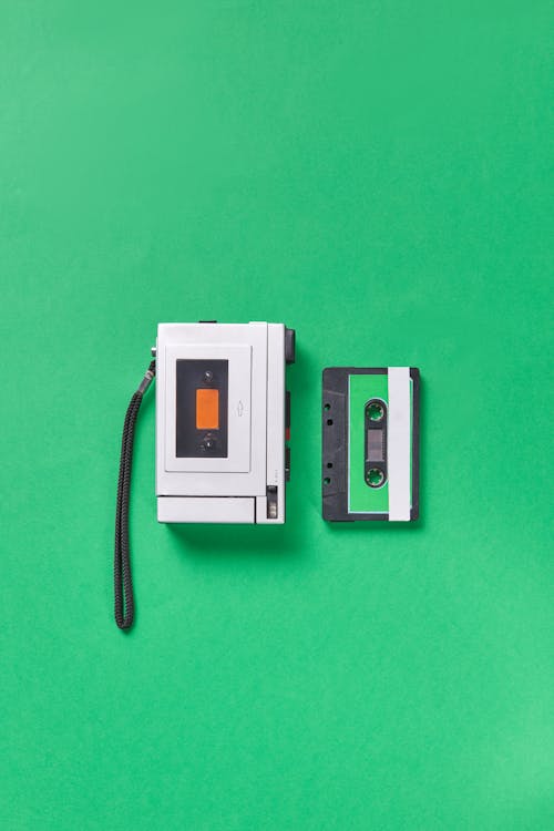 A Cassette Player and Tape on Green Surface