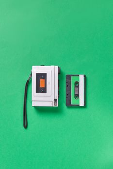 Classic cassette player with a tape on a vibrant green background, showcasing retro technology.