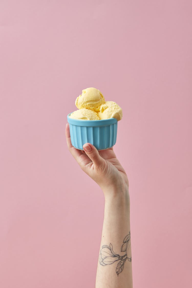 Hand Holding Cup Of Vanilla Ice Cream