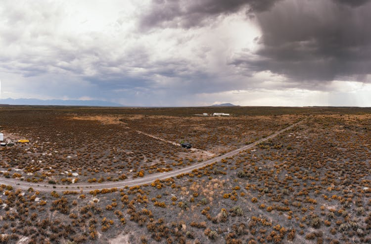 Aerial View Of A Road Through A Wasteland And Mountains In Distance 