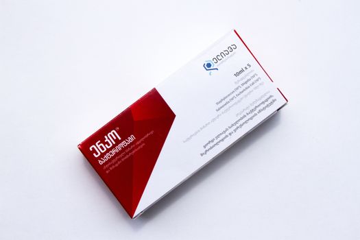 Close-up of a red and white medication box on a white background, showcasing retail packaging.