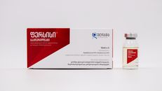 White package and vial of medication displayed on a white background.