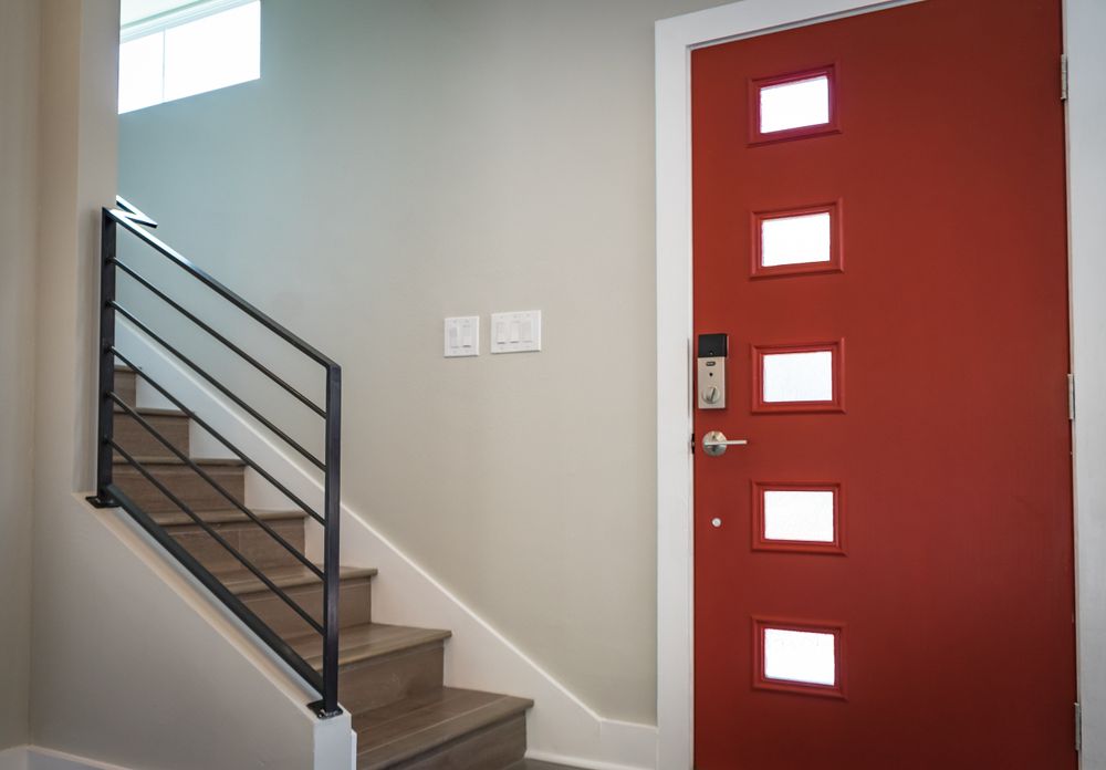 Contemporary interior with vibrant red entrance door and stairs