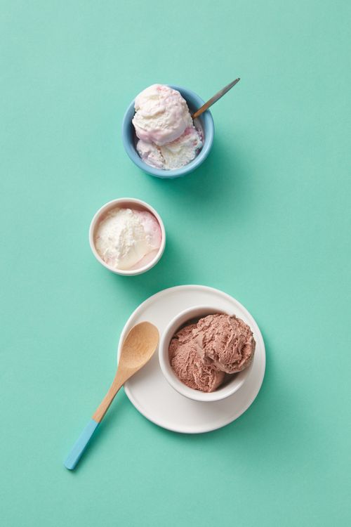 Free Assorted ice cream flavors in ceramic bowls on a turquoise background, featuring chocolate, vanilla, and berry. Stock Photo