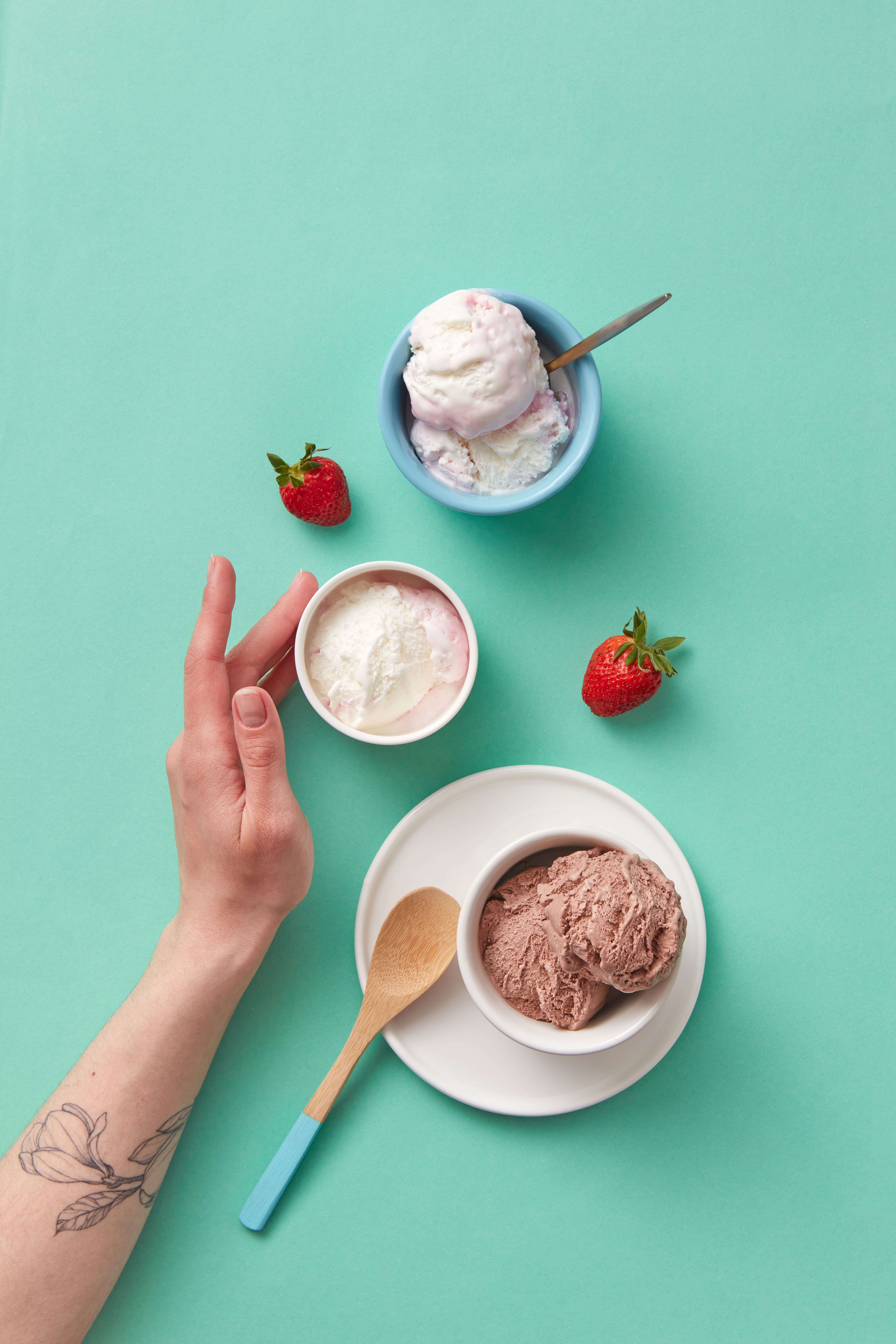 Delicious assortment of ice cream scoops and fresh strawberries on pastel background.