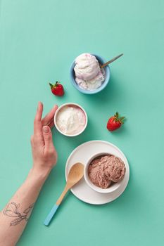 Delicious assortment of ice cream scoops and fresh strawberries on pastel background.