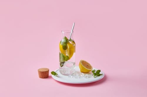 Photos gratuites de assiette en céramique, bouteille en verre, citrons