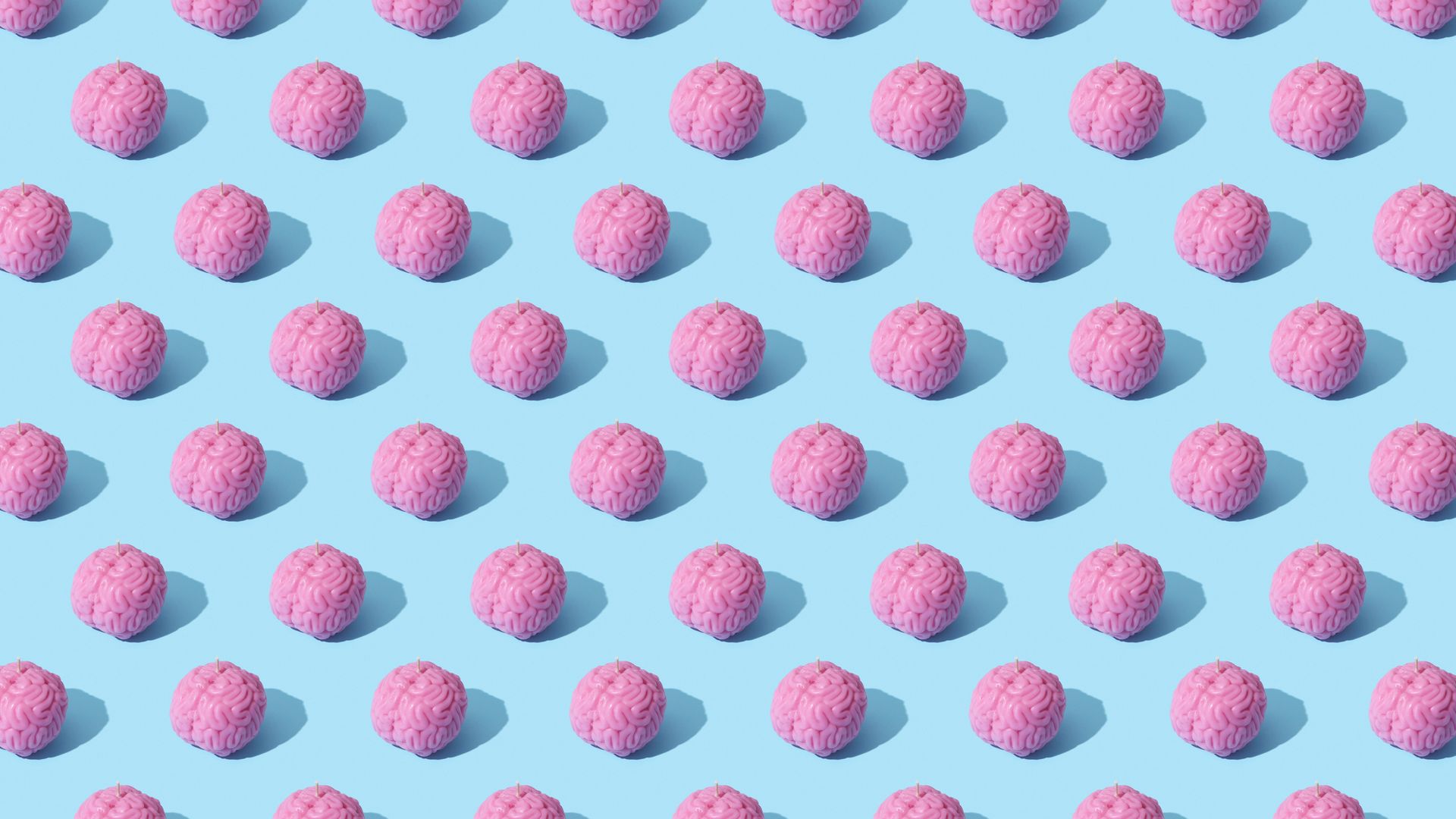 Modafinil's Cognitive Effects: Unlocking Your Brain's Potential Creative composition of pink brain models in a repeating pattern on a light blue surface, showcasing abstract thinking.