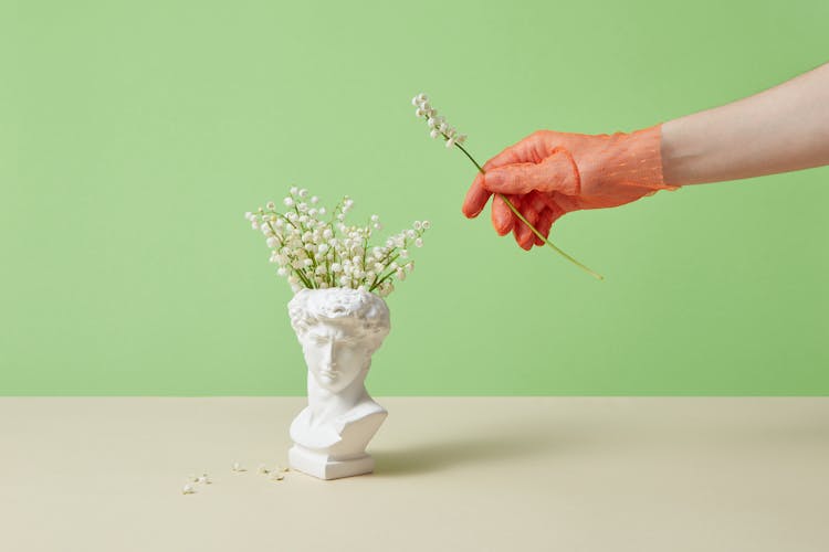 A Sculpture Of A Head As A Flower Vase