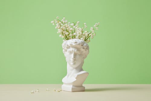 Head Statue with Flowers on Studio Background