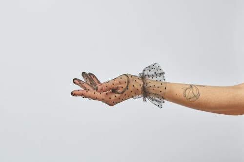 A Tattooed Hand with Polka Dots Glove