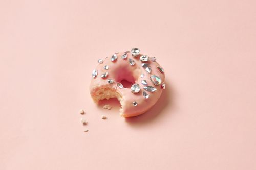 Free A donut with pink glaze and diamond decorations, showcasing luxurious style on a soft pastel background. Stock Photo