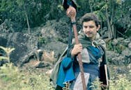 在哥伦比亚的森林中，一名身着中世纪角色扮演服装的男子手持工作人员