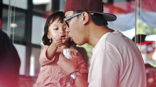 Free Photograph of a Child Feeding Her Father Stock Photo