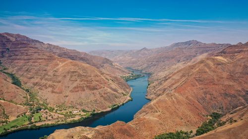 Free A breathtaking aerial view of a river flowing through a stunning mountainous valley landscape. Stock Photo