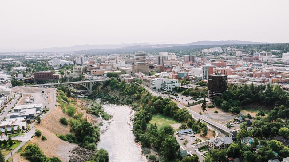 Discover the scenic view of downtown Spokane with flowing river and urban landscape.