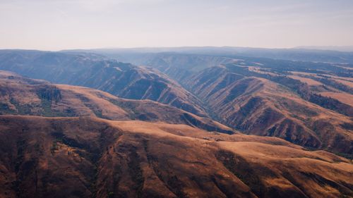 Free Explore the vast and rugged terrain of an arid mountain landscape captured from above. Stock Photo