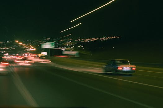 Blurred car lights on a highway at night captured with long exposure photography, showcasing motion and speed.