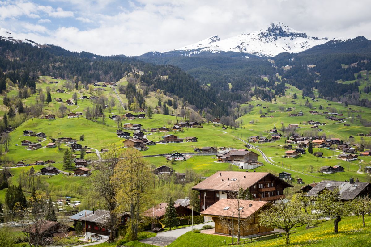 Malownicza wioska w Interlaken otoczona zielonymi wzgórzami i górami